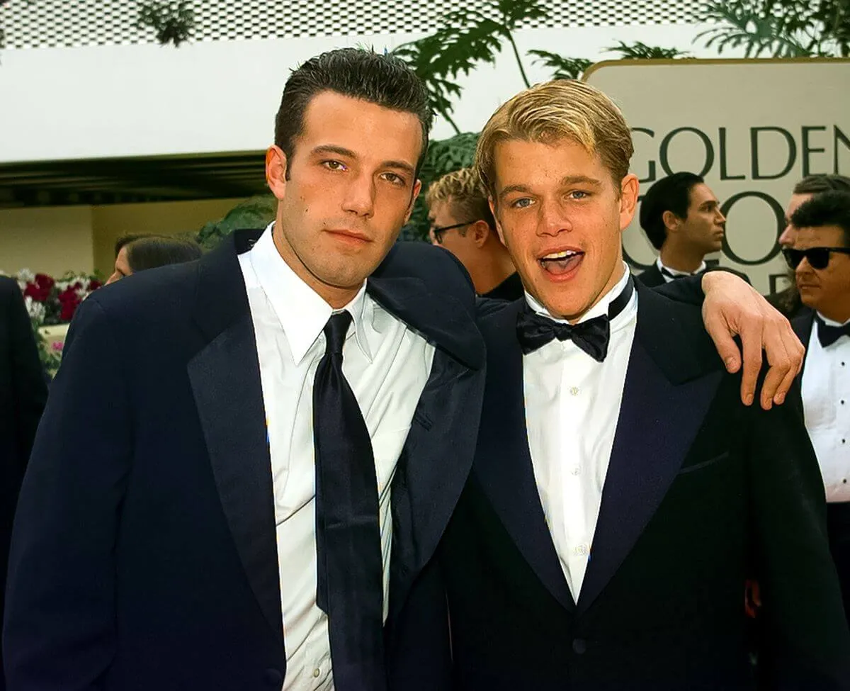 Ben Affleck wears a suit and slings his arm around Matt Damon's shoulder. Damon wears a tuxedo.